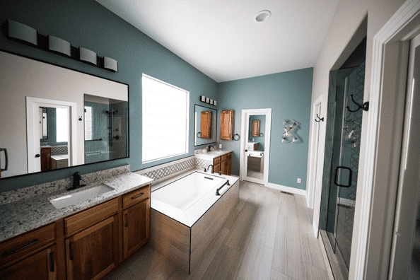 Modern remodeled bathroom with dual sinks and built-in bathtub in Calgary